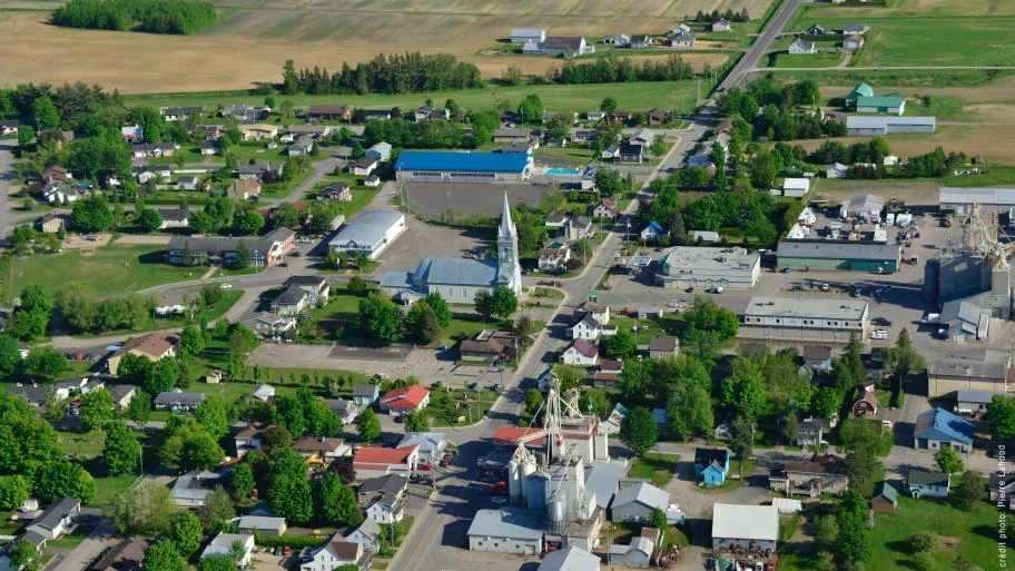 Vue aérienne d'un village rural avec champs.