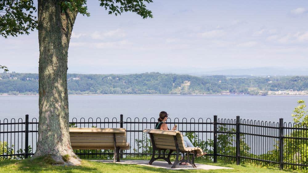 Personne assise sur un banc face au lac