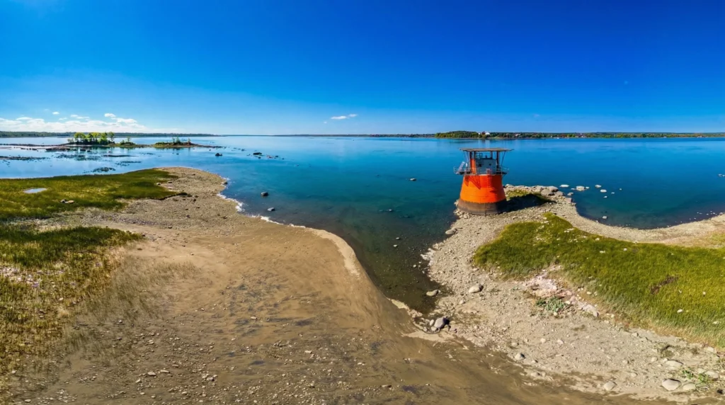 Petit phare orange sur rivage calme