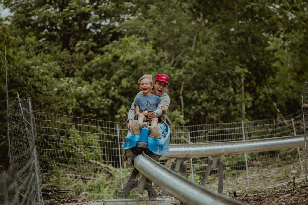 Mère et enfant sur luge d'été en forêt